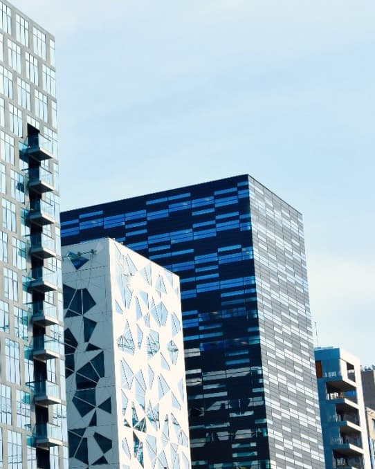 Looking up at a cluster of modern commercial buildings.